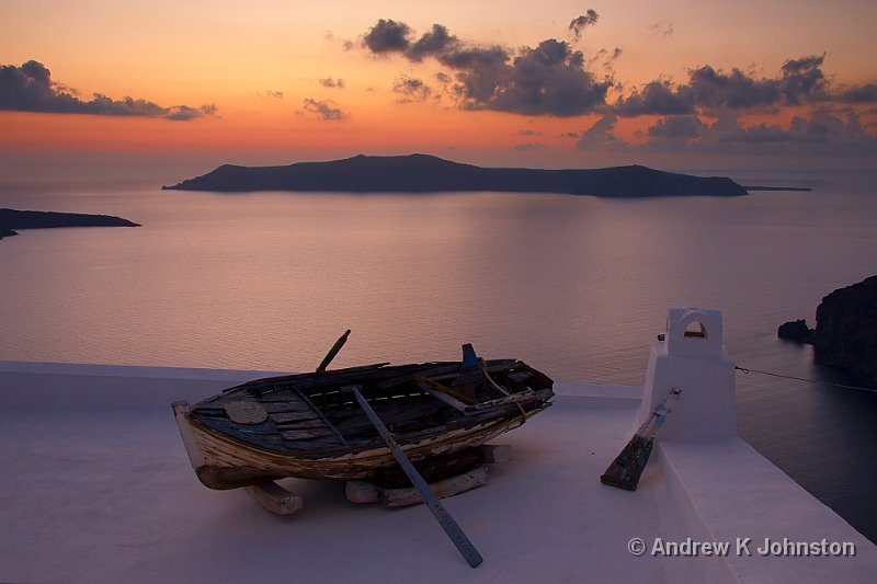 1009_40D_9677.jpg - An old boat decorating a roof against the Santorini caldera sunset